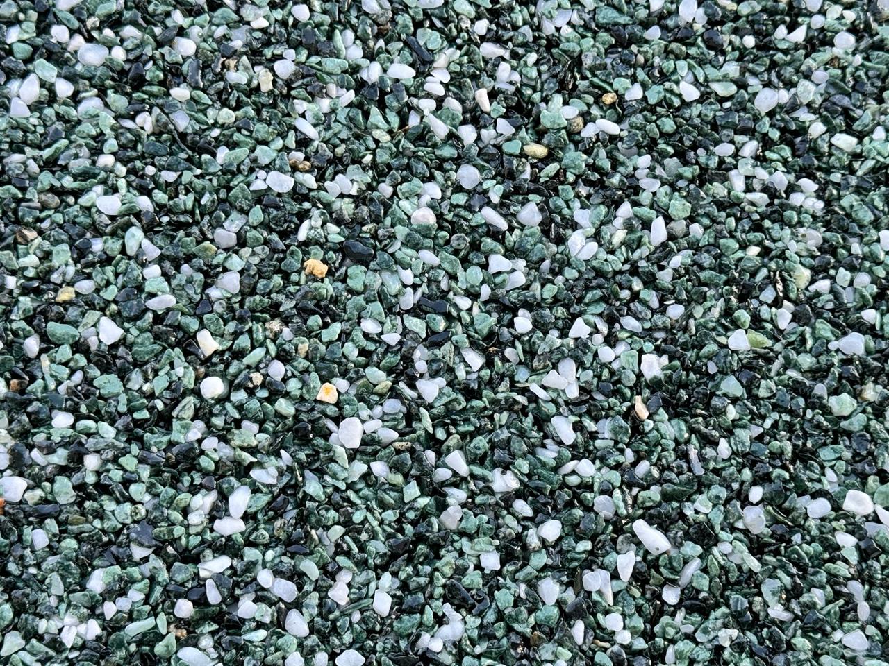 Nahaufnahme grüner Marmorkiesel im Steinteppich